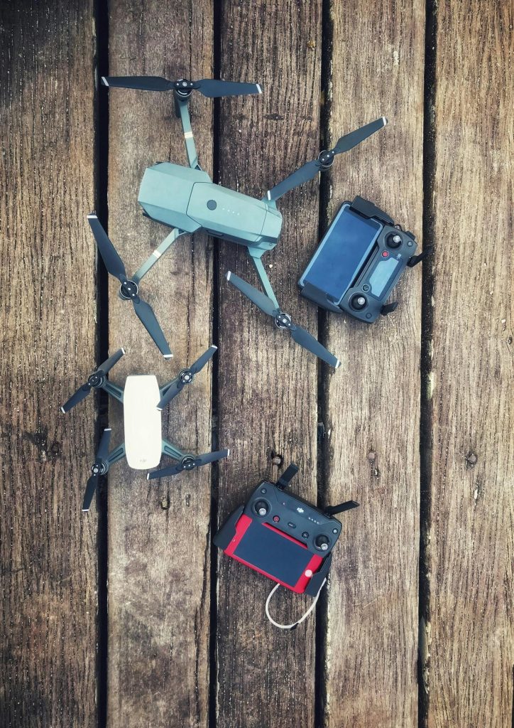 Aerial equipment and controllers displayed on a wooden backdrop, showcasing modern drone technology.
